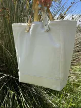 Bolso tote de loneta color crudo con base reforzada y asas cortas de cuero con estampado animal print.