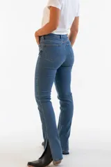 Pantalón jean de denim azul oscuro con doble lycra, tiro medio y botamangas con aberturas laterales.