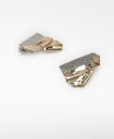 Maxi pendientes metálicos con diseño geométrico y trabajo de pliegues en acabado dorado y plateado.