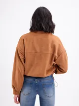 Campera bomber de gamuza sintética color marrón, con cierre frontal, cuello alto y bolsillos frontales con cierre.