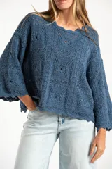 Sweater de tejido de punto calado color marrón, con diseño oversize, cuello redondo y mangas tres cuartos.