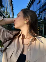 Camisa color beige con cuello clásico, cierre frontal con botones y dos bolsillos con solapa en el pecho.