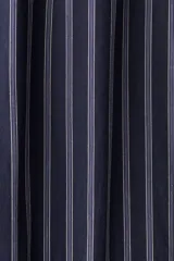 Pantalón de popelina de algodón azul marino con finas rayas verticales blancas. Presenta cintura elástica con cordón ajustable y bolsillos laterales.