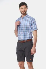 Bermuda cargo color beige con bolsillos laterales y traseros. Se ajusta a la cintura con cinturón de cuero marrón.