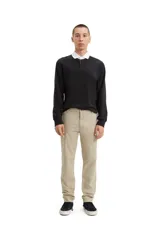 Pantalón chino color beige de gabardina con corte tapered, tiro medio y cierre con cremallera.