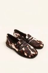 Mocasin de cuero con pelo estampado animal print tipo vaca, con punta cuadrada y suela plana de goma.