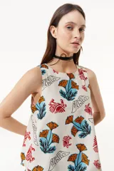 Top sin mangas con cuello a la base, estampado con flores naranjas y pájaros rojos.