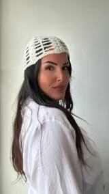 Gorro tipo beanie tejido al crochet con diseño calado y lentejuelas plateadas.