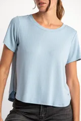 Remera de cuello redondo y manga corta, confeccionada en tejido de viscosa acanalado con un corte holgado y diseño asimétrico en el ruedo, más corto adelante y más largo atrás.