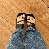 Sandalias chatas negras de cuero vacuno, con base cuadrada y tiras anchas sobre el empeine y el dedo gordo.