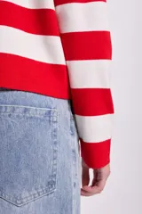 Sweater de punto a rayas horizontales rojas y blancas, con cuello polo y mangas largas.