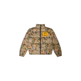 Campera puffer de la marca Drew House con diseño acolchado y cierre frontal. Presenta un estampado de camuflaje floral en tonos verdes, naranjas y lilas, cuello alto y el icónico parche redondo amarillo con una cara feliz y la inscripción 'drew' en el pecho.