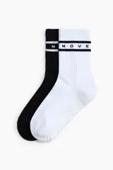Pack de dos pares de medias de yoga antideslizantes, confeccionadas en punto fino de mezcla de algodón, con caña acanalada y diseño a rayas con la inscripción MOVE. Incluye una unidad en color negro y otra en color blanco, ambas con puntos de silicona en la suela para mayor adherencia.