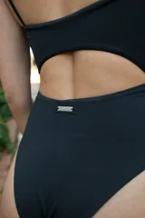 Traje de baño enterizo negro de lycra, con breteles finos regulables, escote con abertura circular y lazos ajustables.