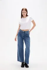 Pantalon de jean azul de corte ancho y tiro bajo, con diseño de cinco bolsillos y cierre frontal con botón y cremallera.