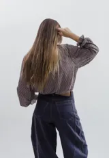 Camisa de tela liviana con estampado geométrico en tonos azul y bordó. Presenta cuello tipo isabelino con volados y lazos, mangas largas abullonadas con puños con volados y cierre frontal con botones metálicos.