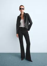 Jeans tiro alto de corte flare color negro, con cinco bolsillos, trabillas para cinturón y cierre frontal con botón y cremallera.
