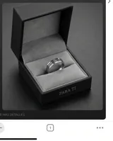 Anillo de acero con diseño de franjas verticales y detalles en esmaltado negro.