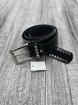 Cinto negro de cuero con hebilla metálica plateada y tachas plateadas.