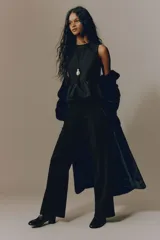 Pantalón sastrero de tiro alto y color negro, con piernas rectas, raya marcada al frente y bolsillos laterales al bies.
