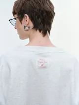 Buzo de cuello redondo y manga larga, con diseño oversize y corte relajado. Presenta puños y ruedo acanalados, confeccionado en tejido de textura suave.