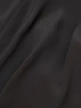 Pantalón palazzo negro de crepe con cintura elastizada, bolsillos laterales y terminaciones en cobre.