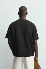 Camiseta de corte relajado confeccionada en algodón con textura irregular, cuello redondo y manga corta.