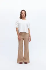 Pantalón de lino blanco, de tiro alto y pierna levemente acampanada.