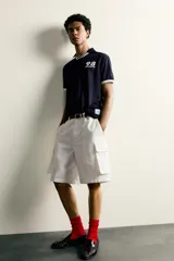Polo de corte relajado confeccionado en tejido técnico, con diseño de rayas verticales en tonos azul marino y negro. Presenta cuello solapa con abertura frontal y detalles de rib en contraste en cuello y mangas. Incluye estampado frontal con el número 98 y la inscripción France, además de una etiqueta aplicada en el ruedo inferior.