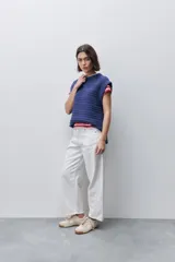 Pantalón jean de tiro alto con calce straight y pierna recta, confeccionado en denim de aspecto limpio. Cuenta con cinco bolsillos, cierre frontal con botón y presillas para cinturón.