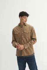 Sobrecamisa verde oliva de pana con cuello solapa, calce holgado, bolsillos con tapa en el pecho y botones personalizados.