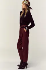 Pantalón de tiro alto y corte tobillero, confeccionado en tejido de aspecto denim oscuro. Presenta diseño de pinzas frontales, bolsillos laterales y cierre frontal con cremallera, botón y gancho. Incluye un cinturón fino a tono con hebilla metálica dorada.