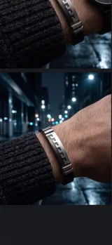 Pulsera masculina con placa central de acero inoxidable que presenta un diseño geométrico tipo greca, combinada con una banda de goma negra.