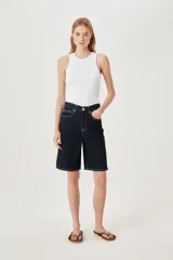Bermuda de jean de tiro alto y corte ancho, color azul oscuro con costuras en contraste. Presenta detalles de trenzado en la cintura y aberturas laterales.