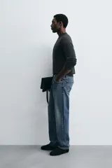 Jeans de corte recto en tono azul clásico con efecto lavado, tiro medio y diseño de cinco bolsillos con cierre frontal de botones.