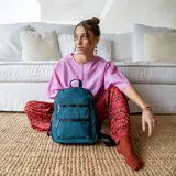 Mochila rosa de tafeta con apertura superior con cierre y tiradores metálicos, bolsillos internos, bolsillo con doble cierre metálico al frente, asas rígidas de mano y correas regulables para colgar en la espalda.