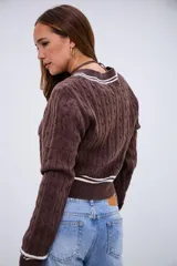 Sweater de punto trenzado color marrón chocolate, con cuello en V y detalles de rayas blancas en el cuello, puños y ruedo.