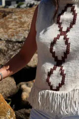Chaleco tejido a mano en lana merino color crudo con diseño calado y flecos en el ruedo.