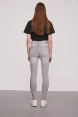 Pantalon jean de corte super skinny y tiro alto, con acabado lavado en tono gris.