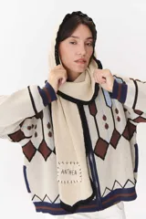 Bufanda de tejido de punto con capucha integrada, diseño geométrico en tonos beige, marrón y azul, y etiqueta bordada con el nombre de la marca.