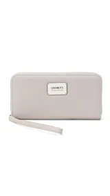 Billetera larga con cierre perimetral, confeccionada en material sintético texturizado color mostaza. Cuenta con correa de mano extraíble y placa metálica con logo de la marca en el frente.