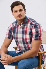 Camisa de manga corta a cuadros con diseño clásico, cuello camisero, cierre frontal de botones y un bolsillo ojal en el pecho con detalle bordado.