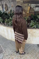 Sudadera marrón de cuello redondo y manga larga, con detalle de lazos en relieve en el delantero y acabados en rib a tono.