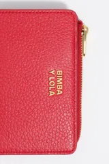 Billetera compacta de cuero vacuno color negro, con cierre superior metálico dorado y logo de la marca estampado en el frente.