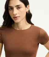 Body de poliamida color topo, con cuello redondo, mangas cortas y cierre en la entrepierna. Diseño ajustado al cuerpo.