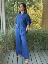 Pantalón blanco de lino, de corte ancho, con cintura elástica y cinturón de rafia extraíble.