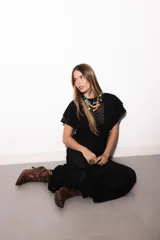 Vestido largo negro de encaje transparente con diseño geométrico, mangas cortas con volados y cuello alto.