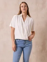 Blusa color blanco de lino, con cuello con solapa y escote en V. Delantera cruzada y mangas cortas. Marca Cable & Gauge.