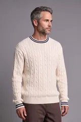 Buzo de tejido de punto con diseño de ochos, color crudo, con cuello redondo, puños y dobladillo acanalados con líneas azul marino y blancas.