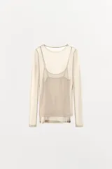 Camiseta de manga larga color beige, con cuello redondo y detalle de camiseta interior en el mismo tejido. Tiene un bajo asimétrico y corte slim fit.